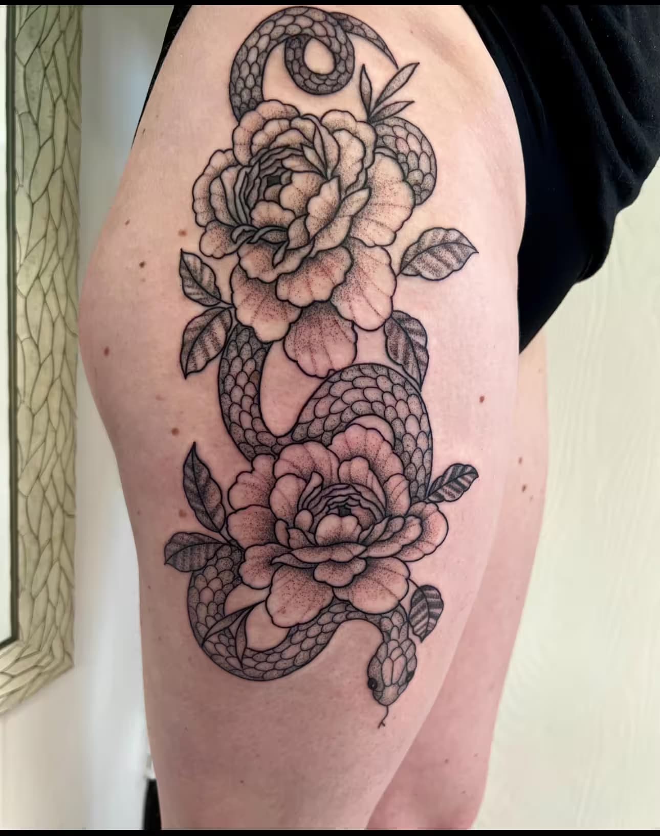 Fine line snake and floral thigh tattoo