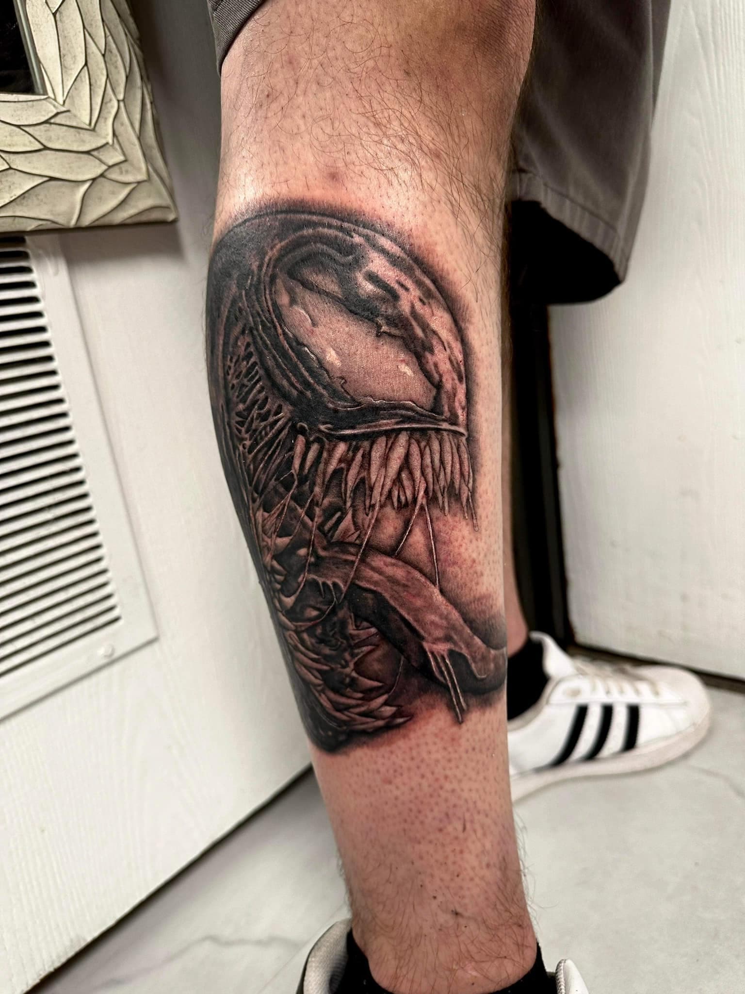 Black and grey realism Venom tattoo on the calf